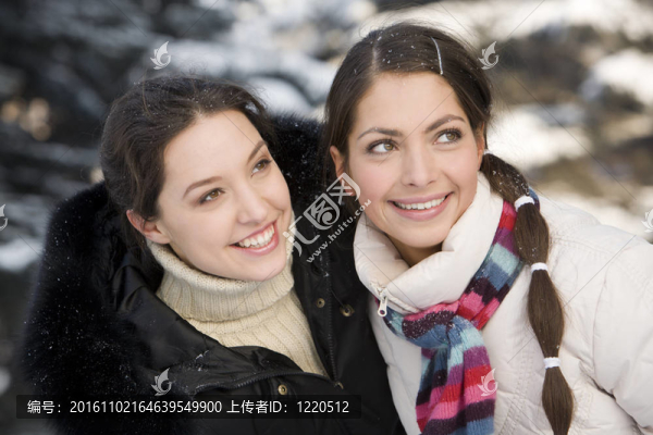 兩個微笑的女孩在冬天的森林里玩耍
