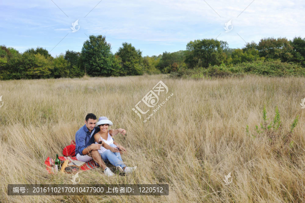 快樂夫婦在長草地享受鄉(xiāng)村野餐