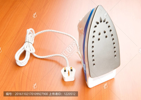 木制背景上的現(xiàn)代電熨斗