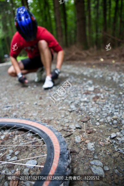 在一個(gè)森林的車友在森林自行車步道山地自行車（淺景深；在前景的自行車輪焦點(diǎn)）