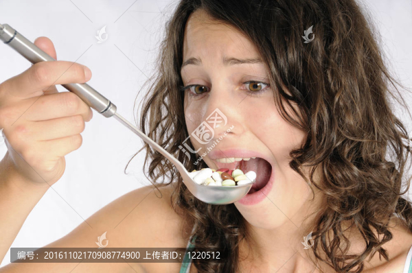 用勺子裝滿藥丸的可愛女孩。另類醫(yī)學概念