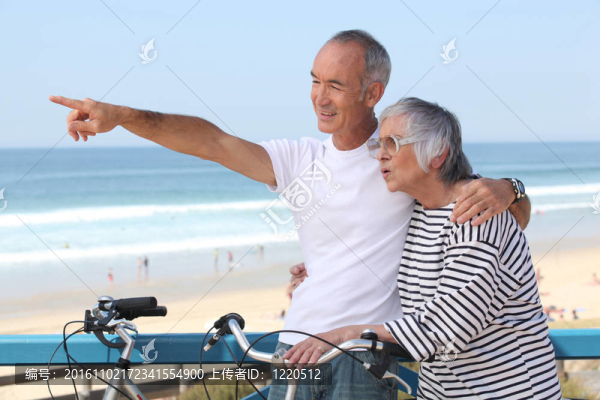 在海灘上騎自行車的高級夫婦