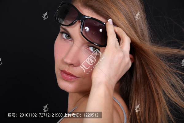 一個女人舉起太陽鏡的肖像