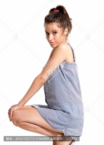 年輕女性穿著睡衣高興蹲孤立在白色背景
