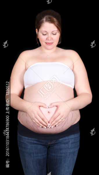 孕婦用手在腹部心形。分離