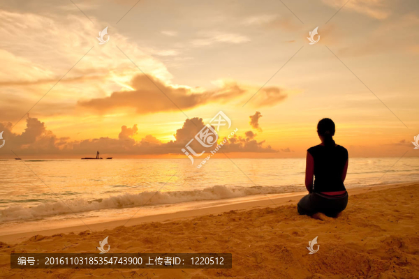 女人坐在沙灘上日落和海洋前
