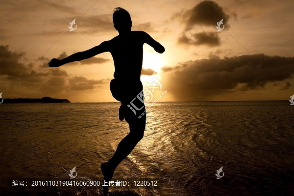 日落時分跳到海邊的男孩剪影