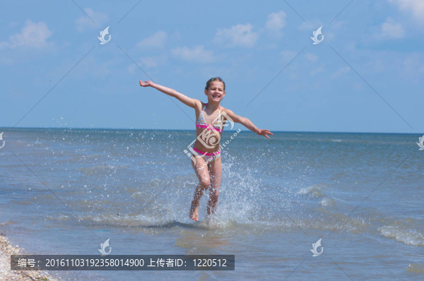 快樂漂亮的女孩在海灘上跑步
