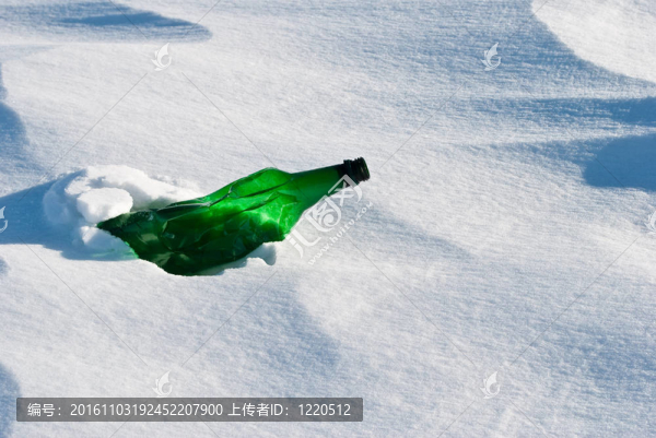 在雪中的綠色玻璃瓶