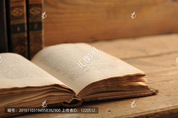 在木制桌子上打開的舊書