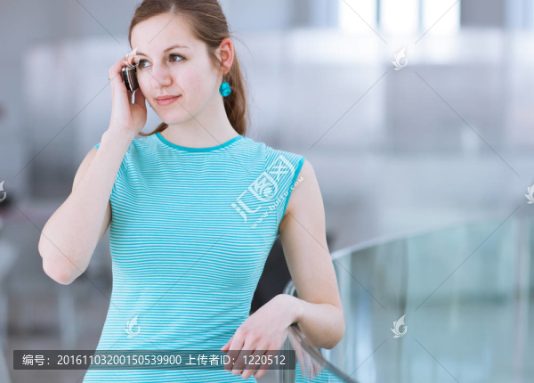 漂亮的年輕女人說她；使用移動電話/手機(jī)在公共區(qū)域（淺景深；顏色色調(diào)的圖像）
