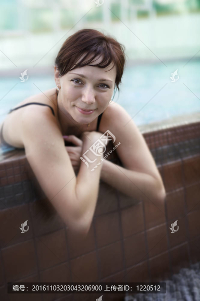 在游泳池里玩得開心的女人。淺景深。