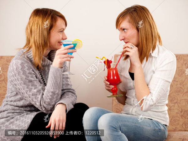 兩個(gè)漂亮的朋友在白色背景上慶祝五顏六色的雞尾酒