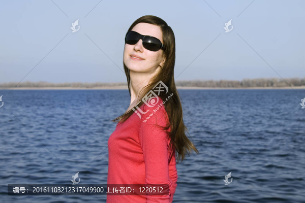 一個年輕漂亮的女人在太陽鏡在大藍天特寫肖像