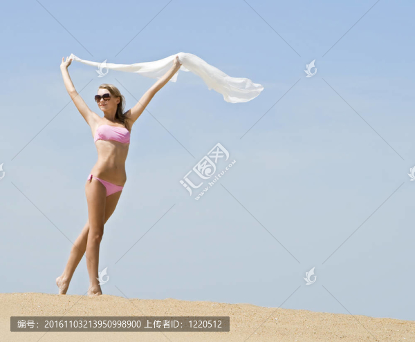 女子在海灘上用白色絲綢圍巾吹的風(fēng)