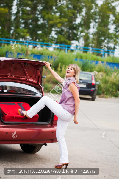 女孩把手提箱裝在汽車行李架上