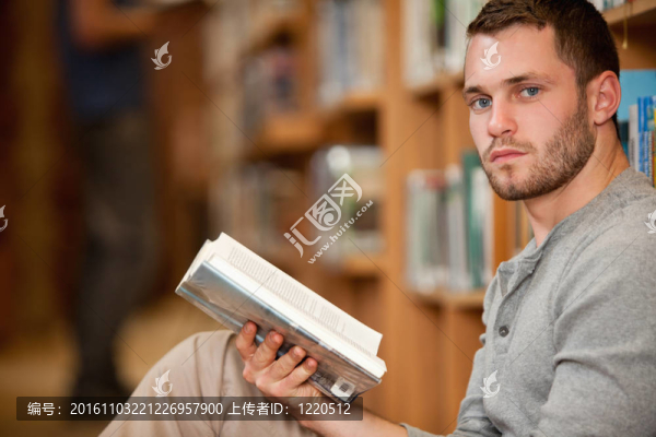 嚴肅的男學生拿著一本書