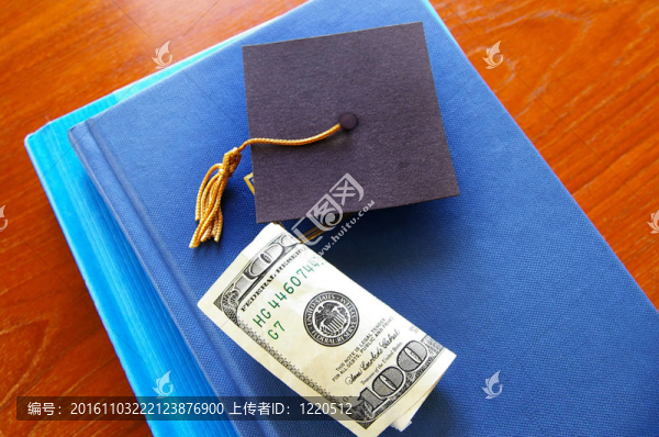 一堆書上的現(xiàn)金和小畢業(yè)帽