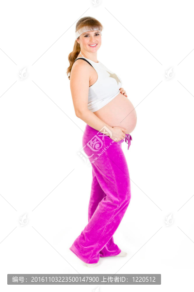微笑美麗孕婦穿著運(yùn)動(dòng)服抱著她的肚子孤立在白色