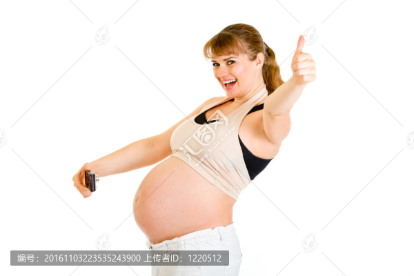笑孕婦拍攝她的腹部和顯示拇指的手勢孤立在白色