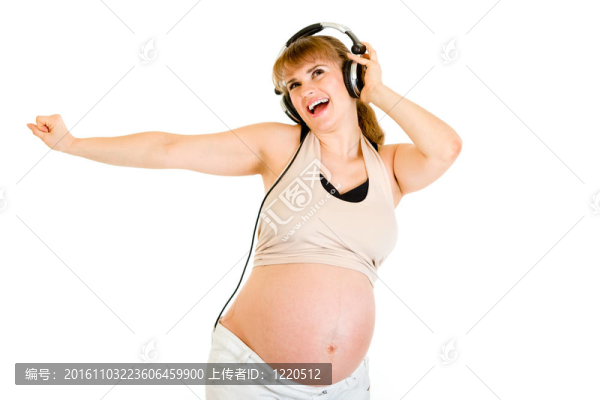 快樂孕婦聽音樂在白色耳機隔離