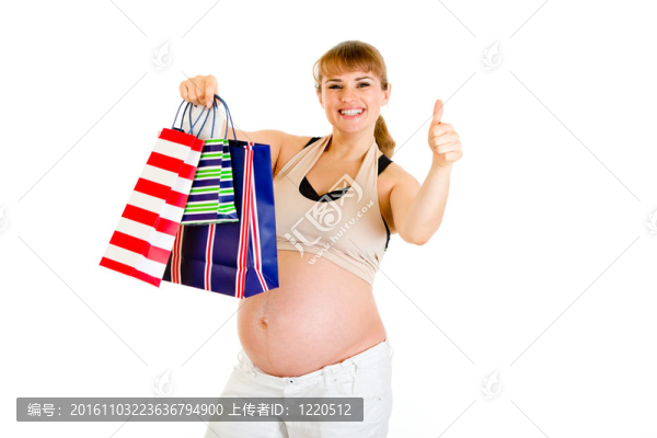 快樂的孕婦抱著購物袋，露出大拇指在白色上孤立的手勢