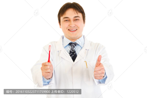 面帶微笑的牙醫(yī)拿著牙刷，在白色上露出豎起大拇指的姿勢