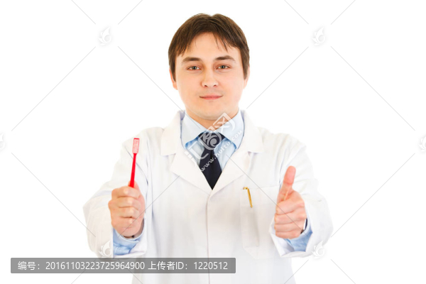 面帶微笑的牙醫(yī)拿著牙刷，在白色上露出豎起大拇指的姿勢