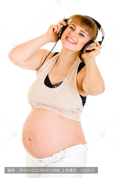 快樂(lè)孕婦聽(tīng)音樂(lè)在白色耳機(jī)隔離