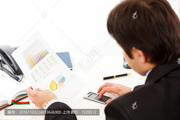坐在辦公桌前檢查財務(wù)報告的商人