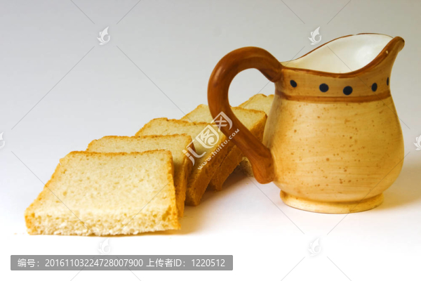在白色背景上的面包和牛奶壺片