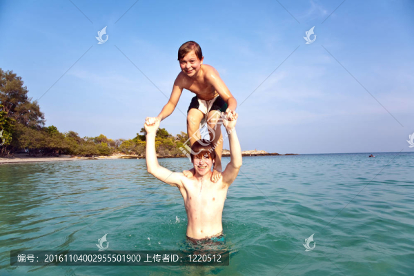 兄弟們一起在湛藍的天空中在清澈的海水中一起在海上跳躍