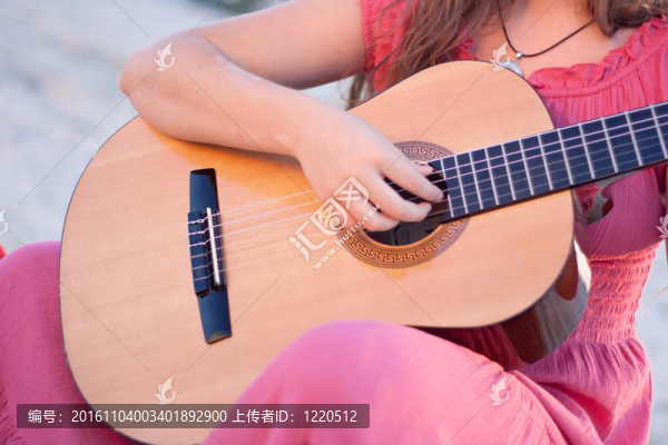 穿著衣服彈吉他的女孩