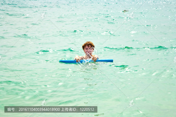 小男孩喜歡騎在美麗的海上沖浪板