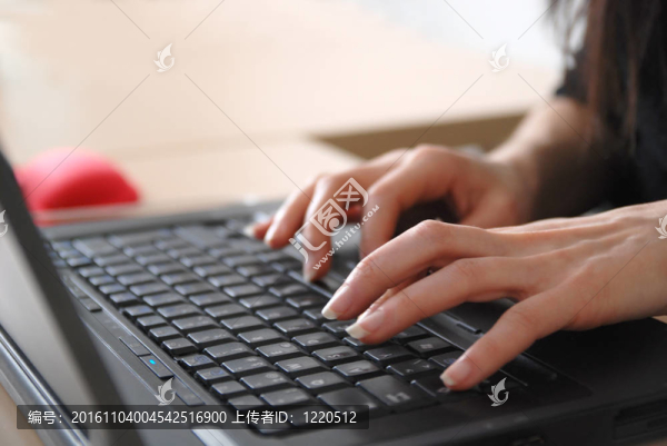 女子在筆記本電腦鍵盤上打字