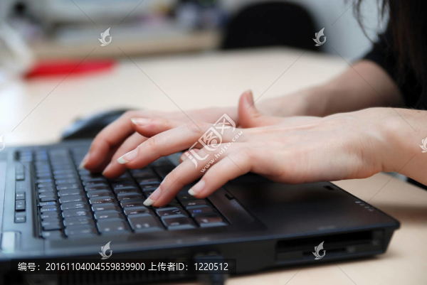 女子在筆記本電腦鍵盤上打字