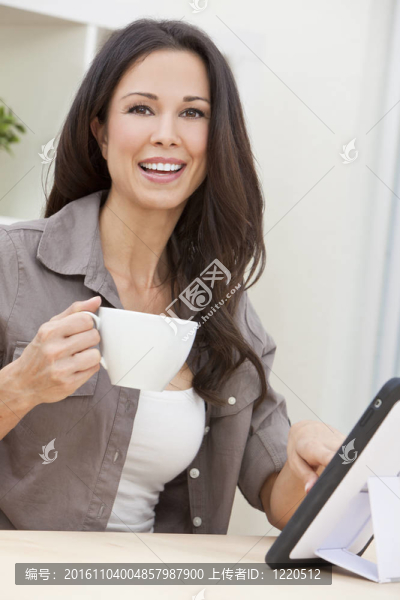 女性在家使用平板電腦喝茶或咖啡