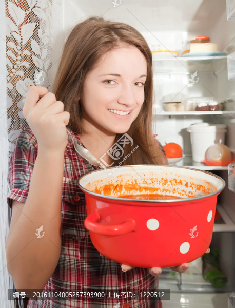 女孩吃湯泛近frigidaire