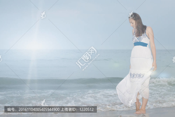 一個女孩站在海灘上俯視