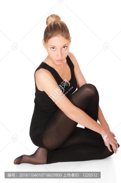 美麗的年輕女子坐在地板上孤立的白色背景
