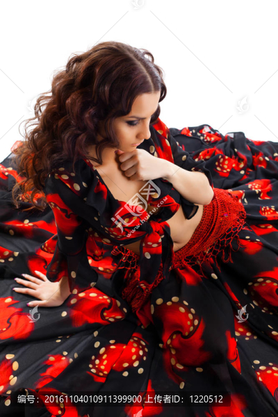 年輕女子坐在吉普賽黑色和紅色服裝