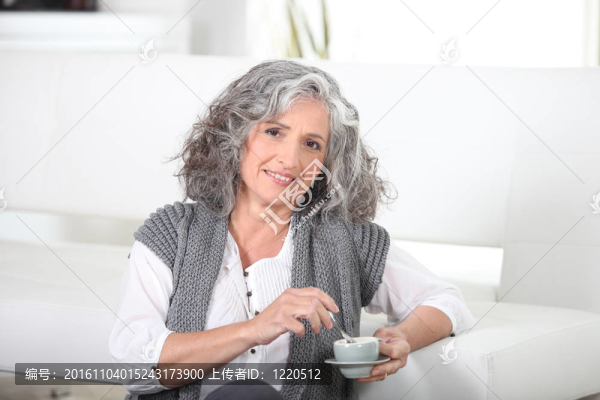 女人坐在地板上喝著咖啡