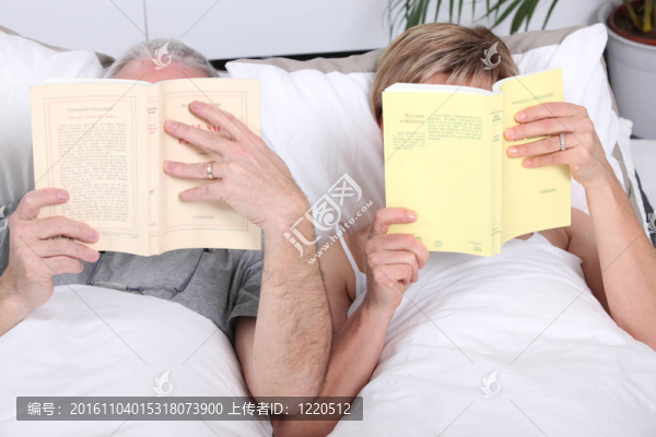 躺在床上看書的夫婦