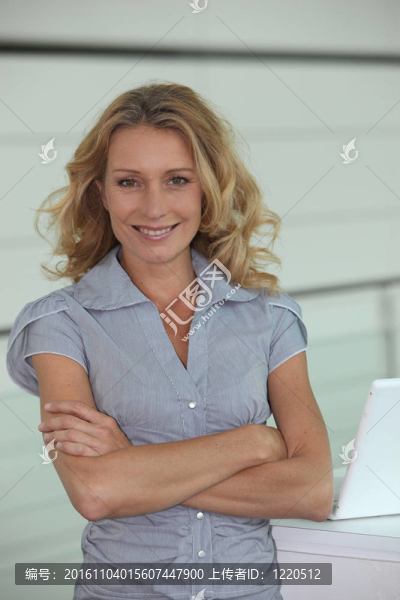 婦女站在手臂旁邊的筆記本電腦
