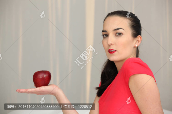 女人手里拿著一個(gè)紅蘋(píng)果