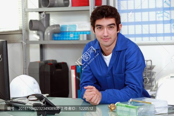 年輕人穿著藍(lán)色工作服在辦公室