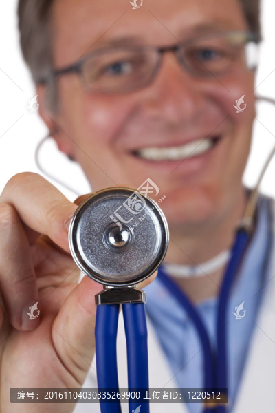 接近微距的听诊器；用微笑的男医生举行