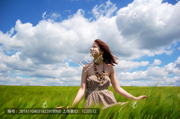 年輕漂亮的女孩在綠色的田野