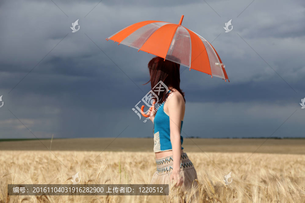 雨天在麥田里帶雨傘的女孩