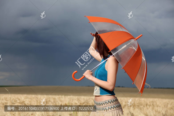 雨天在麥田里帶雨傘的女孩